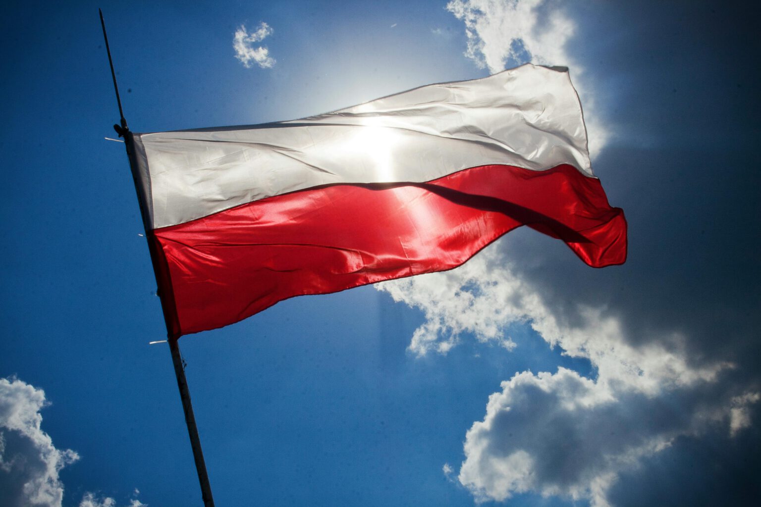 Polish flag flying in a blue sky