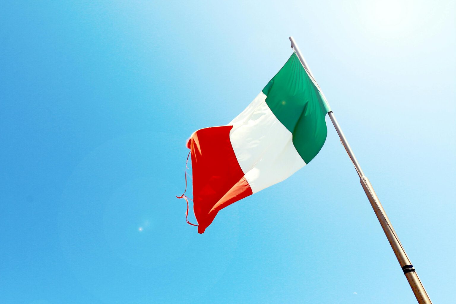 Italian flag waving in blue sky