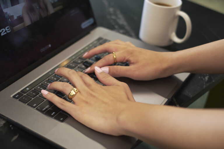 Close-up of a transfeminine person using a keyboard.